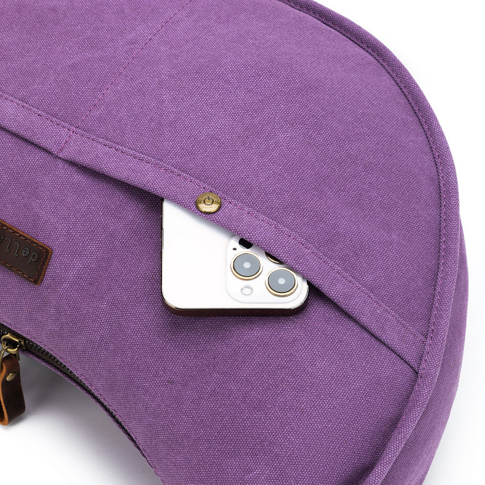 Purple bag with a phone peeking out of a pocket on a white background
