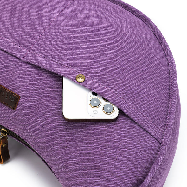 Purple bag with a phone peeking out of a pocket on a white background