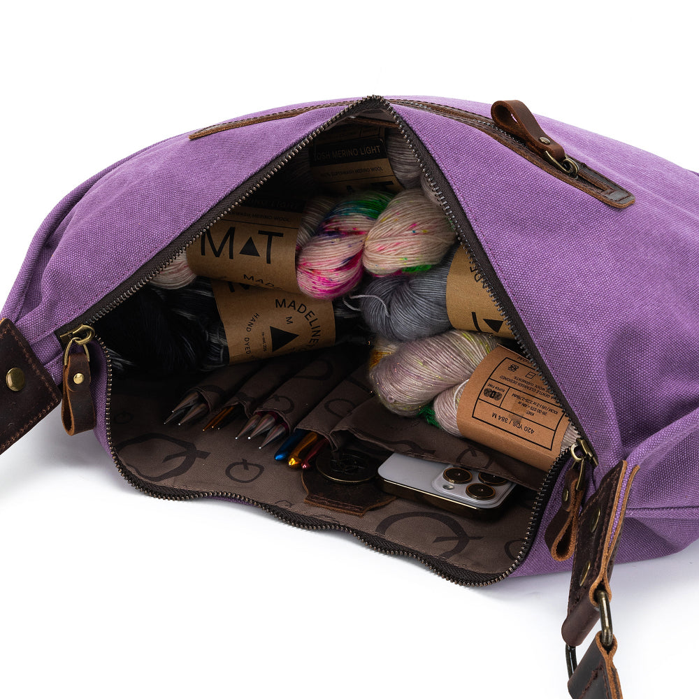 Purple bag with yarn and tools inside on a white background