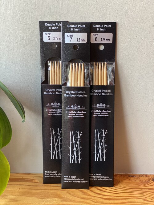 Packaging of Crystal Palace Bamboo Double-Pointed Needles showing multiple sets of needles, with sizes indicated on the labels.