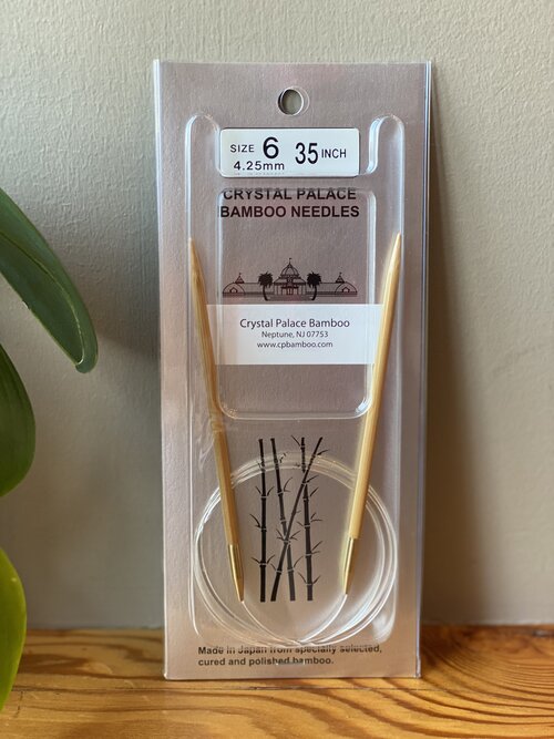 Packaged bamboo circular knitting needles with a size indicator of 6.35 mm displayed in a clear plastic case.