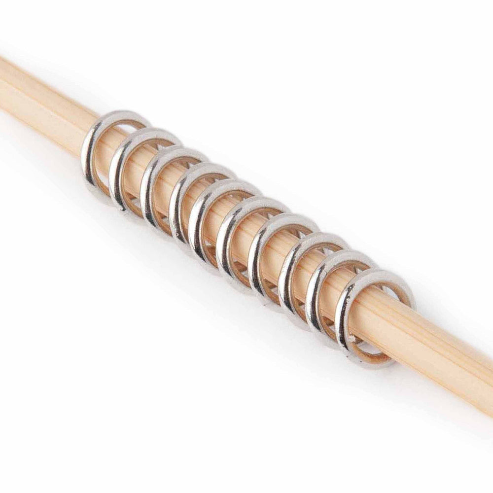 Wooden knitting needle with metal stitch markers a white background