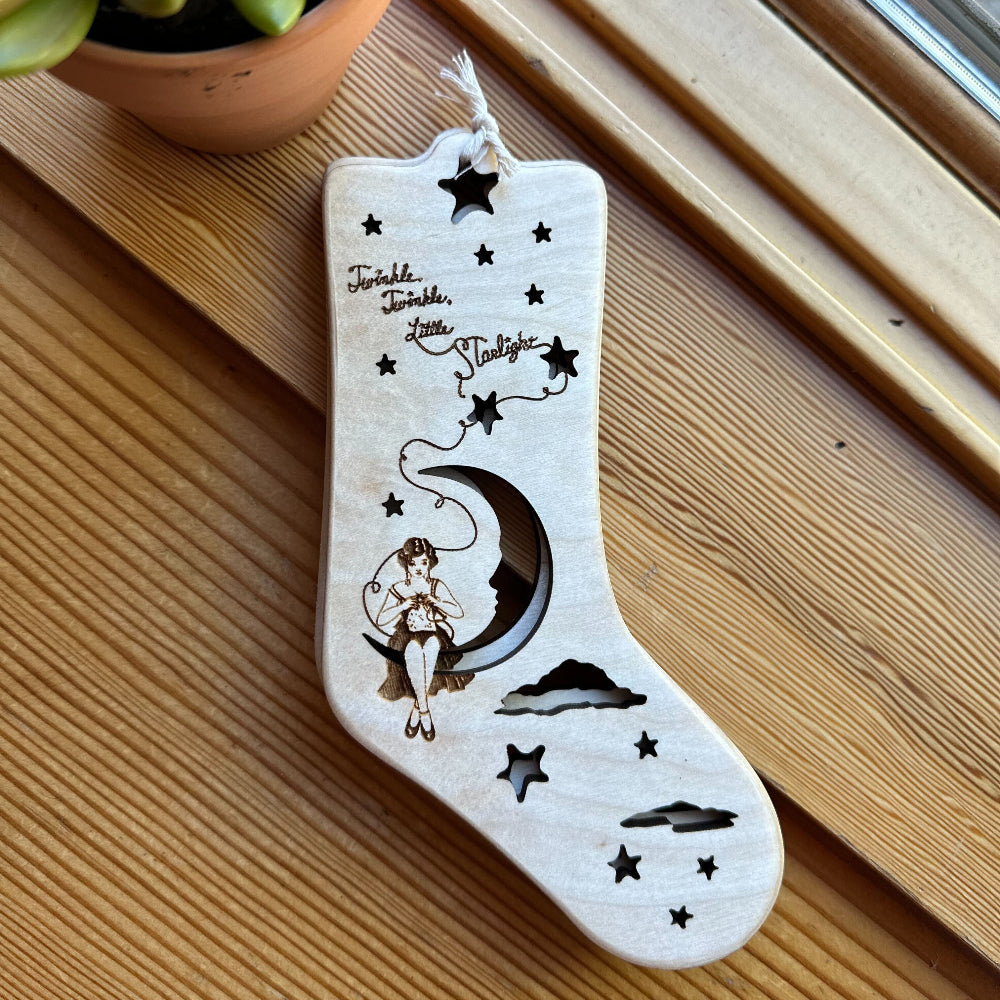 Decorative stocking with moon and star design on a wooden surface