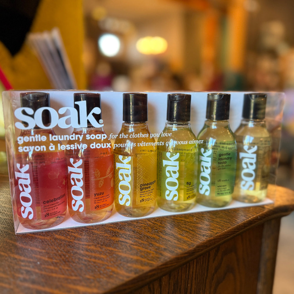 Set of Soak laundry soap bottles on a wooden surface with a blurred background