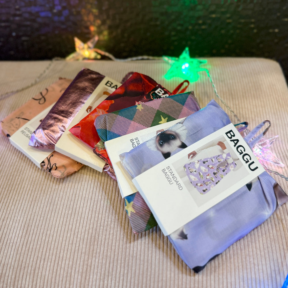 Collection of Baggu bags with colorful designs on a textured surface.