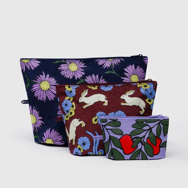 Set of three fabric pouches with floral and animal patterns on a white background