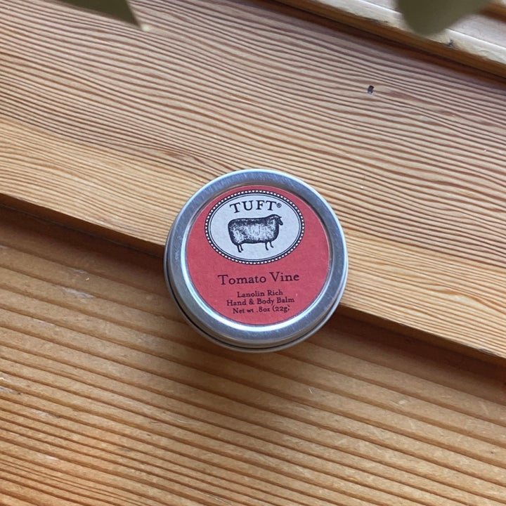 Small tin labeled 'TUFT' Tomato Vine on a wooden surface
