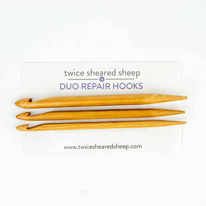 Three wooden repair hooks on a white background with 'twice sheared sheep' branding.