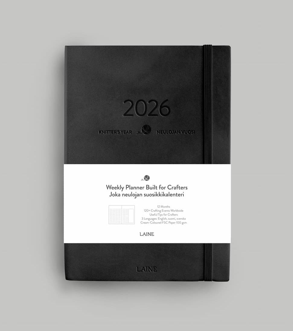 Black planner with white label on a gray background