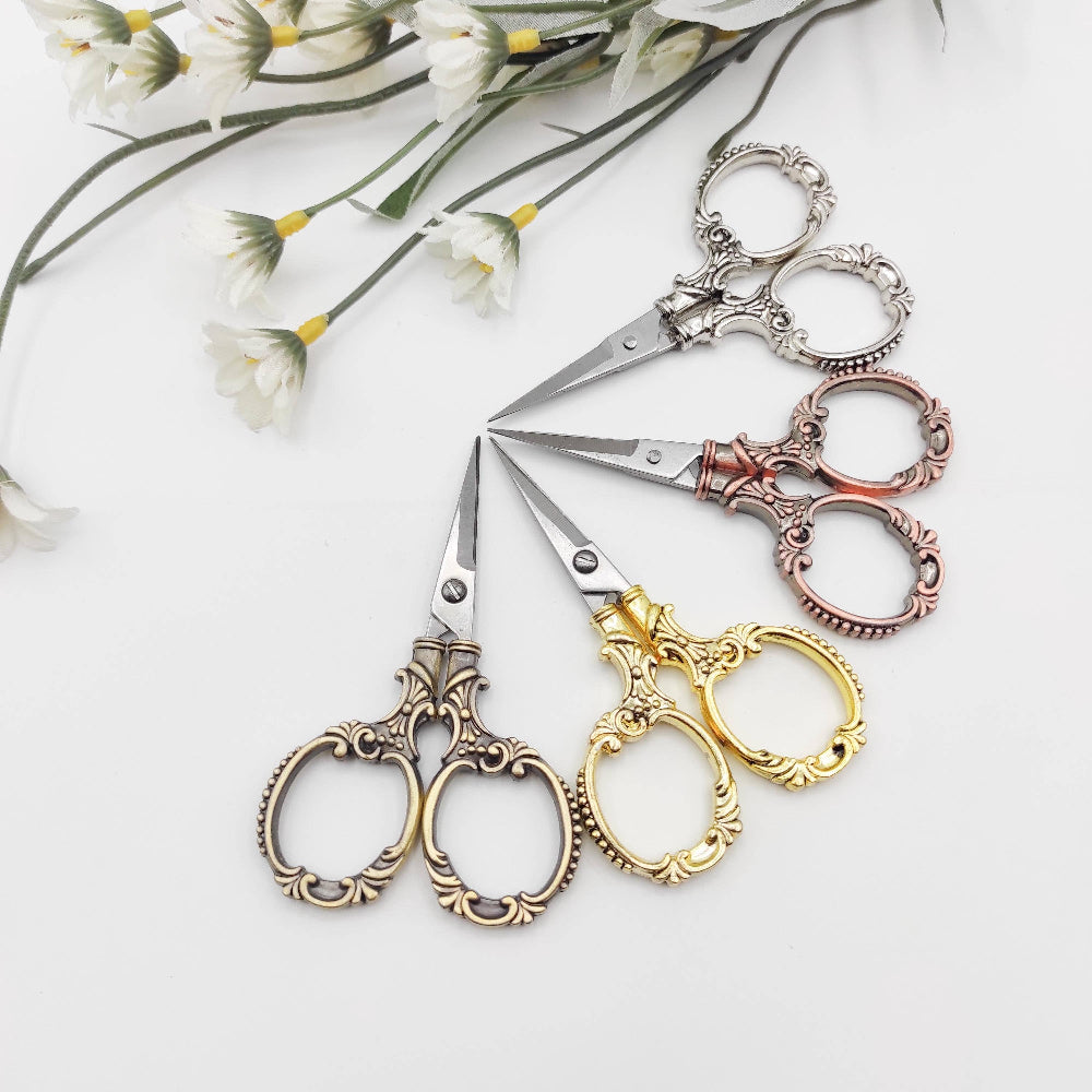 Set of ornate scissors in various colors on a white background with flowers.